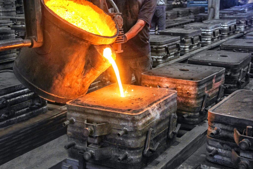 Molten metal poured from a ladle into molds on a foundry line, highlighting precision American manufacturing.