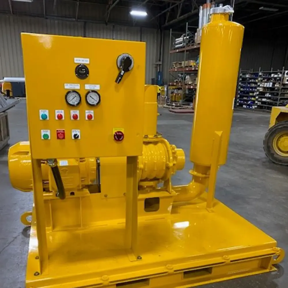 Yellow industrial vacuum pump skid with control panel, pressure gauges and silencer on steel base in Hi-Vac shop